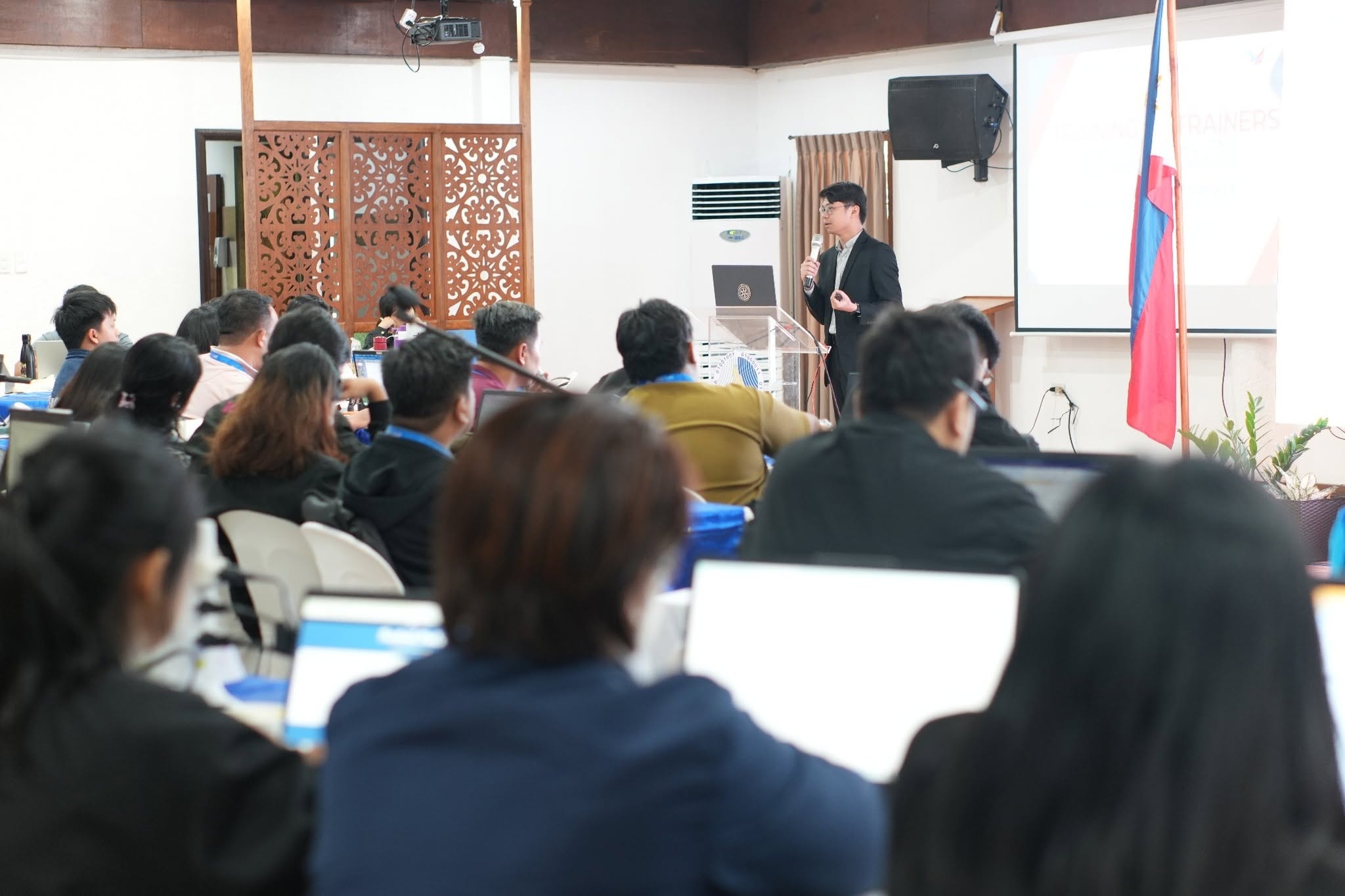 Ellirie Aviles addressing a full audience at a training event